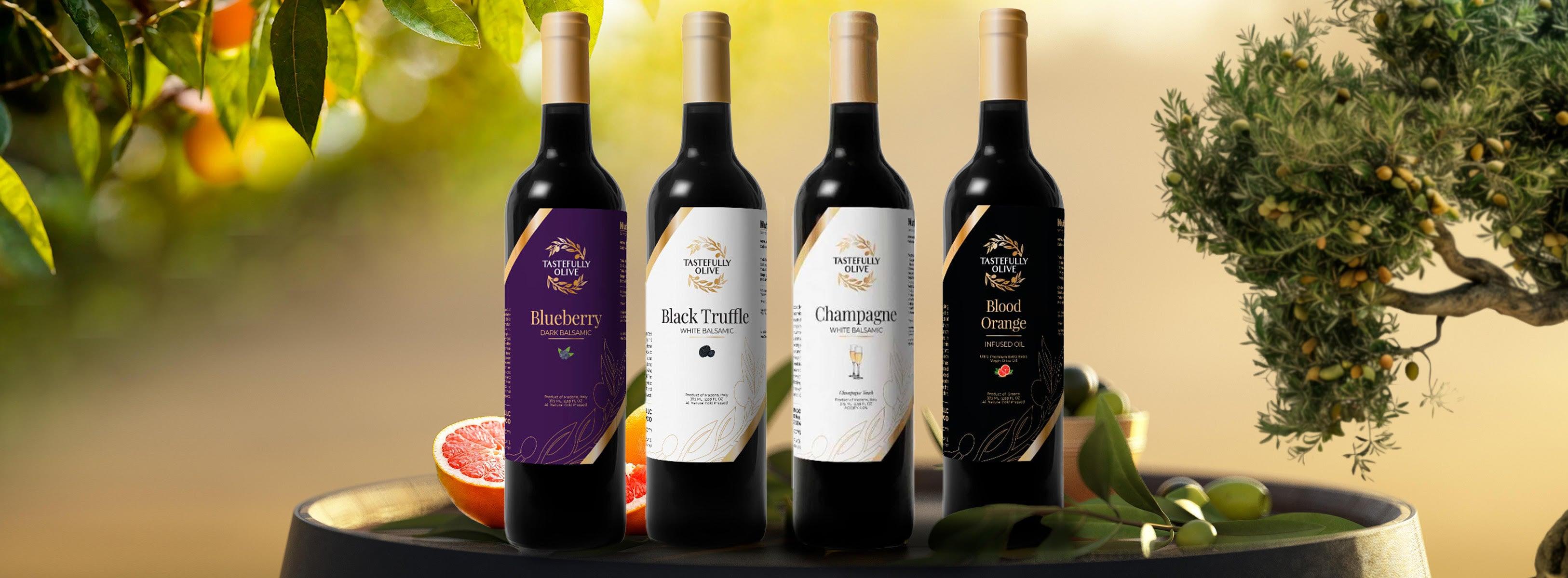 Four bottles of Tastefully Olive balsamic vinegars and infused oil with fresh fruit and olives