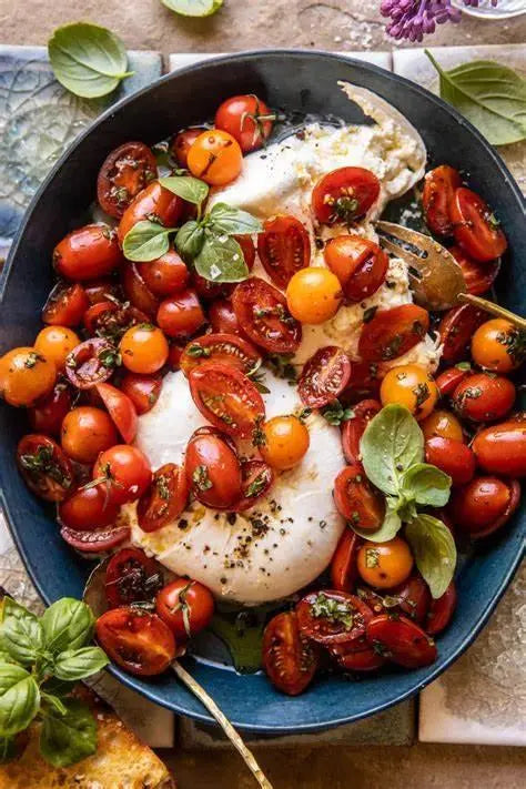 Fresh burrata cheese with roasted cherry tomatoes, basil, and olive oil drizzle