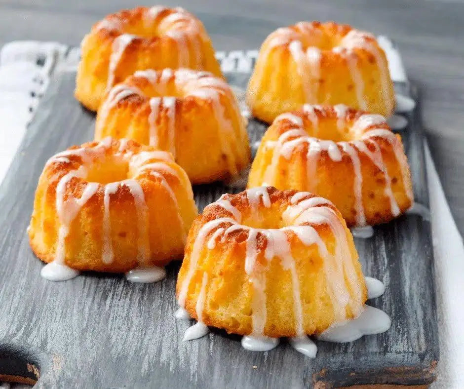 Mini bundt cakes with white glaze on rustic wooden board