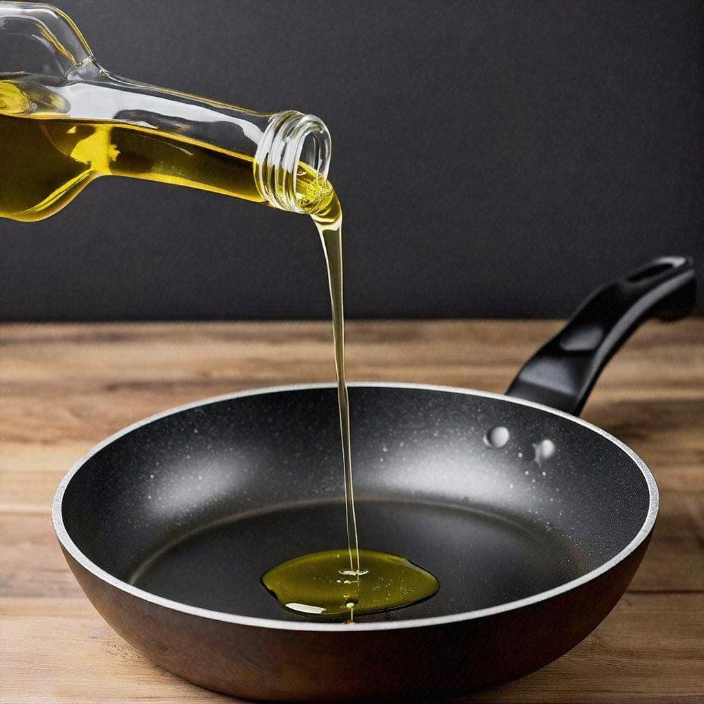 Premium olive oil pouring into a non-stick frying pan for cooking