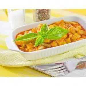Hearty vegetable stew with fresh basil, served in white dish—perfect with premium olive oil