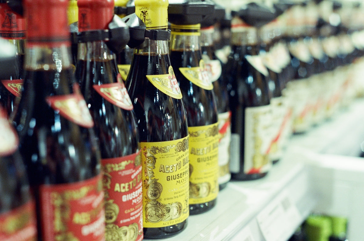Bottles of balsamic vinegar on a grocery store shelf.