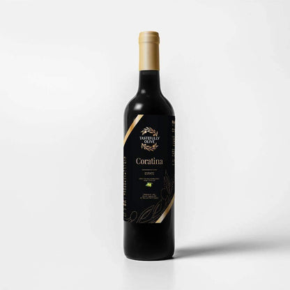 A dark glass bottle with a gold-capped neck, labeled "Coratina | Puglia, Italy" by Tastefully Olive in a black-themed design, stands against a white background. Cold-pressed to retain its rich polyphenols, this olive oil promises exceptional quality and taste.